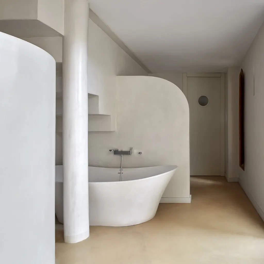 Baño minimalista con microcemento blanco, bañera exenta y ducha de obra en Elche