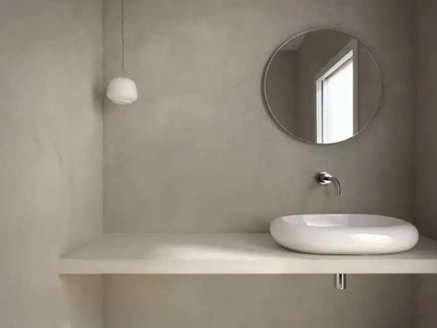 Baño minimalista con microcemento gris oscuro, encimera continua y lavabo redondo sobre encimera en Elche