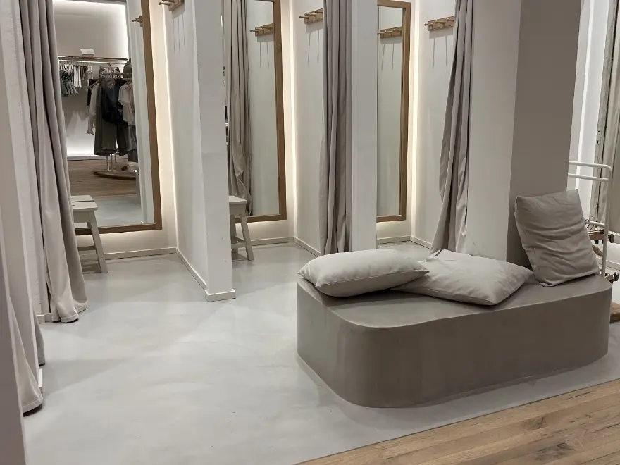 Suelo de microcemento interior en espacio comercial con acabado continuo y elegante