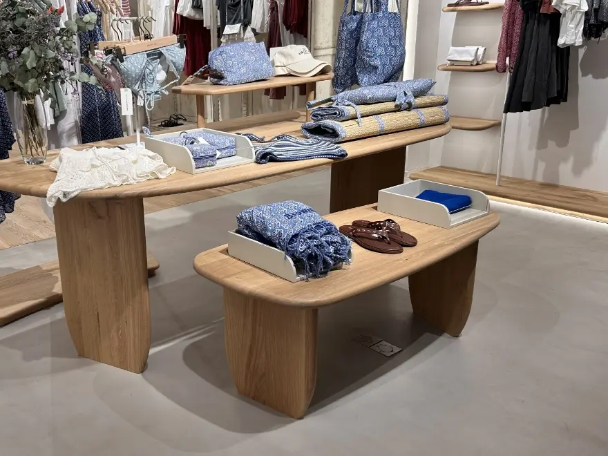 Tienda con suelo de microcemento blanco y expositores de madera en local comercial de Elche