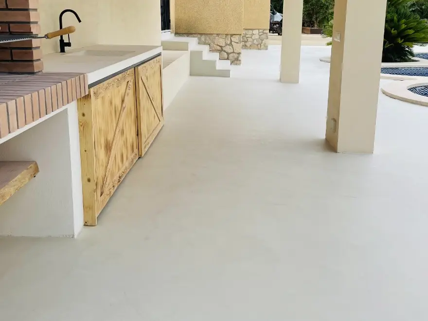Suelo de microcemento exterior continuo en porche con cocina integrada