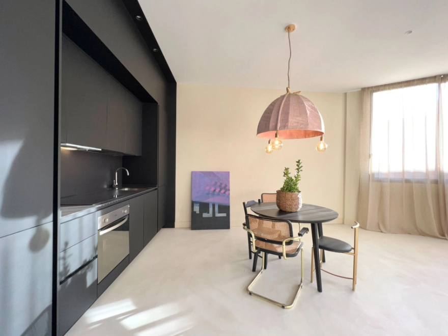 Cocina abierta y luminosa con microcemento blanco en vivienda de Elche