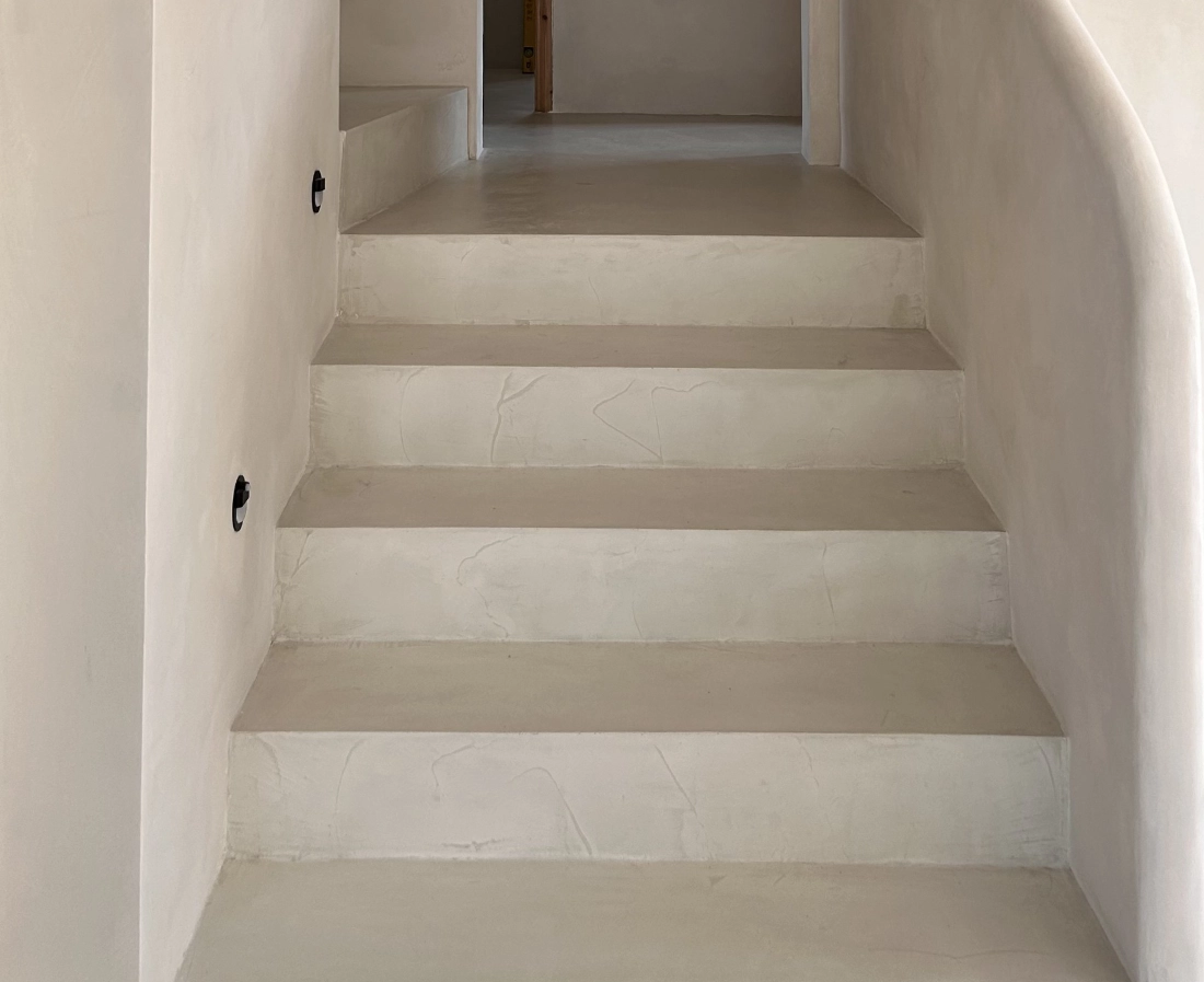 Escalera con microcemento gris claro vista lateral en vivienda de Elche