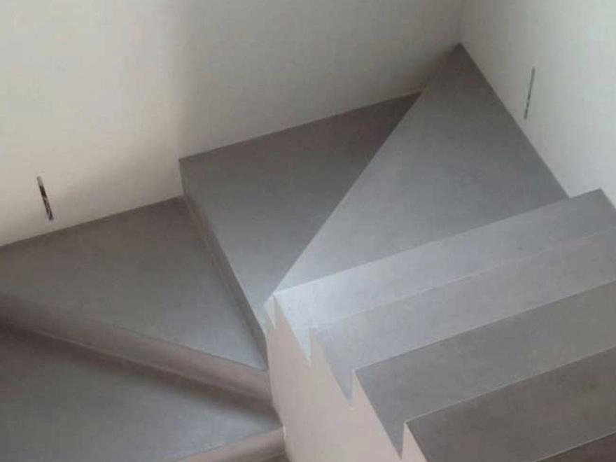 Escalera flotante con microcemento gris y peldaños volados en Elche