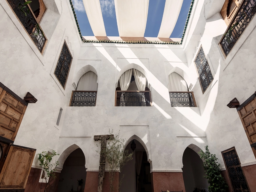 Patio interior con microcemento blanco y arcos de estilo árabe mediterráneo en Elche