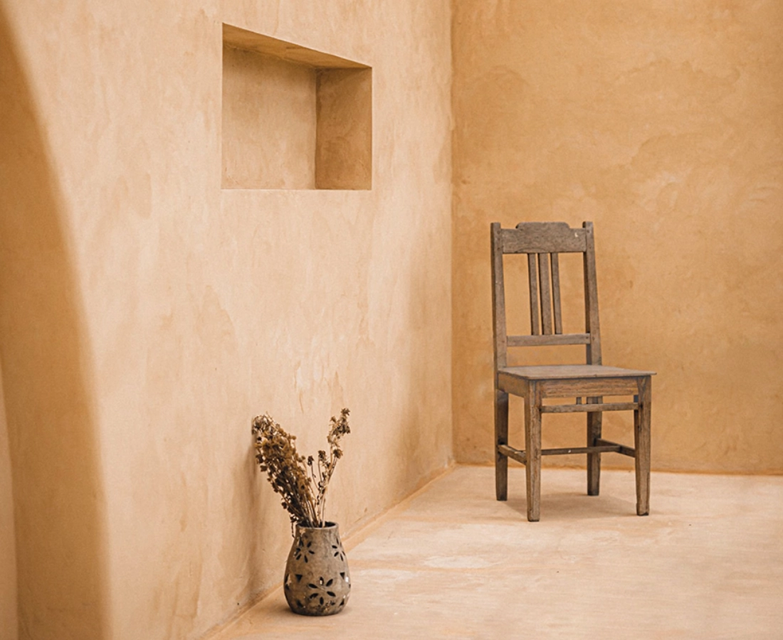 Paredes y suelo de microcemento en tono tierra ocre con nicho decorativo en Elche