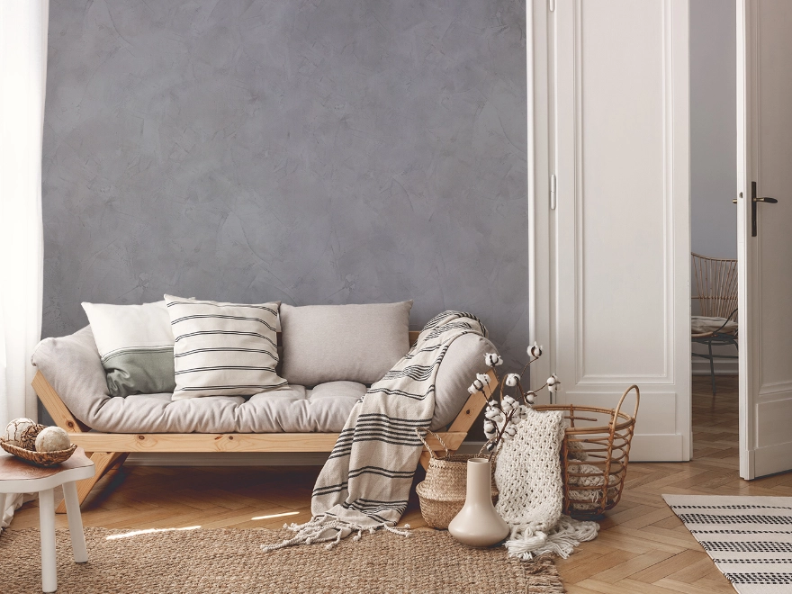 Salón con microcemento beige, sofá blanco y decoración natural en Elche