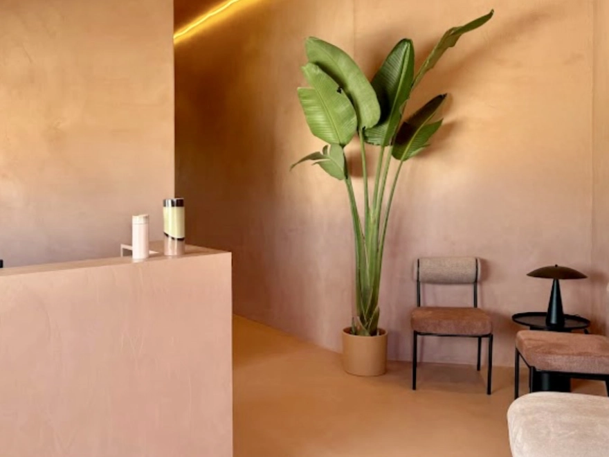 Recepción de local comercial con microcemento rosa nude en paredes, suelo y mostrador en Elche