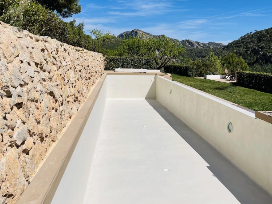 Piscina infinita con microcemento blanco y vistas a la montaña en chalet de Elche