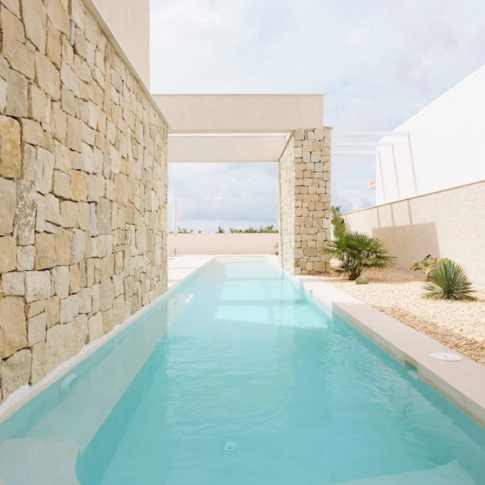 Piscina exterior con microcemento azul turquesa en chalet de Elche